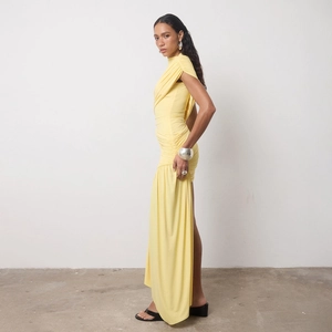 Detail of elegant yellow wrap dress with gathered waist and flowing side drapes
