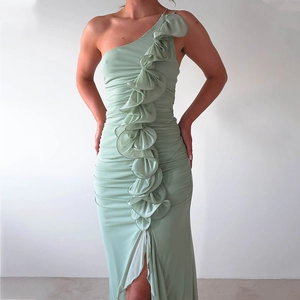 Detail of mint green one-shoulder dress with layered ruffles and elegant pleated texture