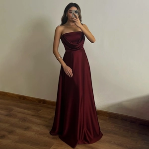 Close-up of elegant burgundy satin long dress with draped neckline and high waistline