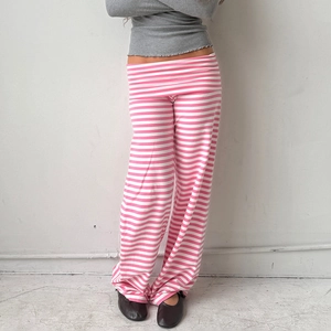 Detail der rosa-weiß gestreiften weiten Hose mit weichem Stoff und niedrigem Bund-Design
