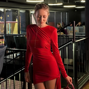 Detailed close-up of the red long-sleeve dress with crossover pleats and knot detail