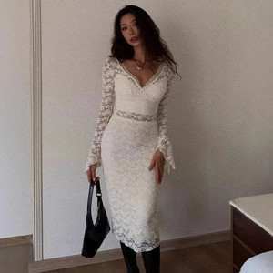 Gros plan détaillé sur robe en dentelle blanche à col en V et manches en cloche