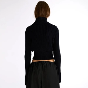 Detail of black ribbed knit sweater showing high collar and slim fit back design
