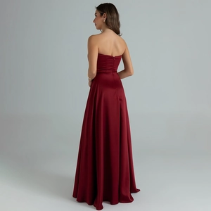 Detail of the back zipper and flowing satin fabric on a wine red strapless evening gown
