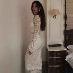 Détail en gros plan d'une robe blanche à manches longues avec dentelle florale au crochet
