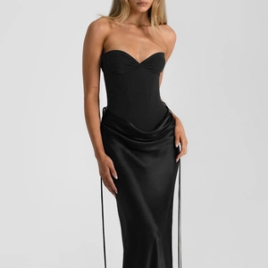 Detail of elegant black strapless mermaid dress with corset bodice and satin draped skirt