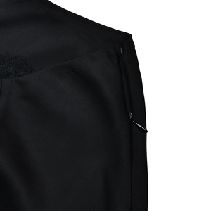 Detail of hidden side zipper and delicate black lace trim on a slim fit maxi dress