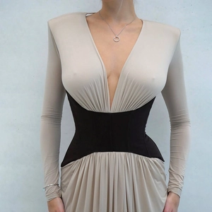 Detailed view of deep V-neck dress with padded shoulders and contrast corset waist design