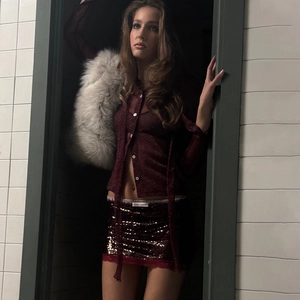 Camicia trasparente rosso vino con minigonna di paillettes e pelliccia finta