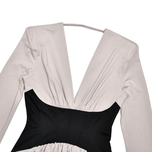 Detail of deep V-neckline and waist stitching on slim-fit grey and black dress