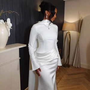 Detail of waist draping and pleats on a white satin long-sleeve evening gown dress