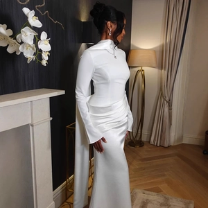 Detail of white satin evening dress featuring pleated waist and elegant back cape train