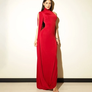 Détail d'une robe rouge dos nu avec un design unique de manche cape longue jusqu'au sol
