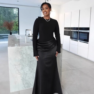 Detail of elegant waist pleats and satin skirt on black slimming evening floor-length gown