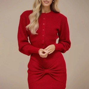 Detail of red ribbed knit dress featuring a front button placket and large decorative bow