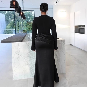 Detail of elegant black evening gown featuring a sleek back zipper and draped satin skirt