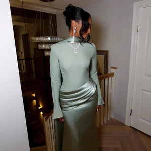 Detailed view of sage green evening gown with cutout neckline and satin pleated texture
