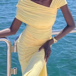 Detail of light yellow ruched maxi dress with off-shoulder cut and slim fit design