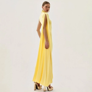 Détail d'une robe de soirée jaune à licou avec des manches cape longues et fluides