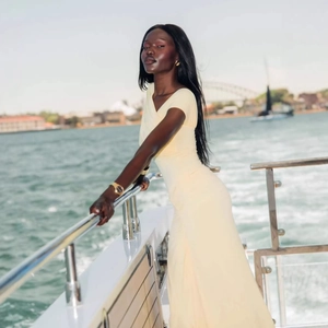 Detail of light yellow ruched maxi dress with side slit on a luxury yacht deck
