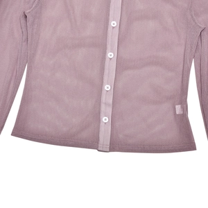 Dettaglio della texture in mesh rosa con bottoni bianchi sulla camicia a maniche lunghe