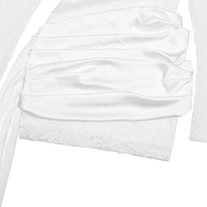 Close-up of white lace embroidery and pleated satin details on long sleeve dress