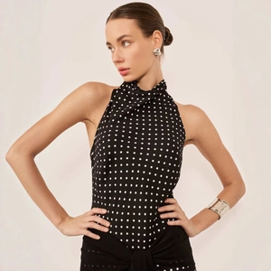 Detail of a halter neck polka dot top with sleeveless design and open back style