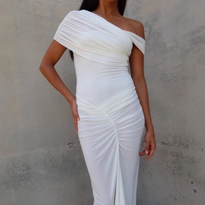 Detailed view of the white off-shoulder ruched dress with elegant pleated fabric texture