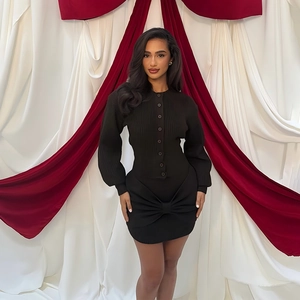 Close-up of black ribbed knit skirt featuring a large decorative bow on the front