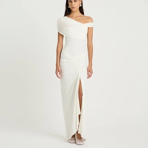 Detail of white one-shoulder maxi dress featuring elegant ruched pleats and high side slit