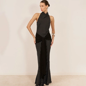 Detail of waist tie and draping ribbon on a black and white polka dot halter dress