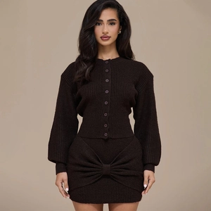 Close-up of ribbed knit set detailing the buttoned cardigan and large decorative front bow