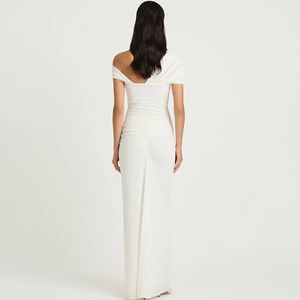 Detail of the elegant white off-shoulder ruched dress with high-quality draping fabric texture