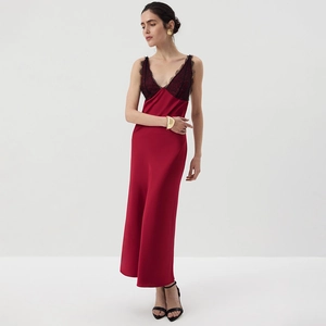 Detail of red satin dress featuring intricate black lace trim on a deep V-neckline