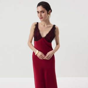 Detailed close-up of the delicate black eyelash lace trim on a red satin evening dress