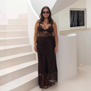 Détail d'une robe noire élégante à col en V profond avec dentelle et fini satiné
