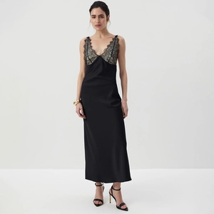 Detailed view of deep V-neckline with delicate eyelash lace on a black satin slip dress