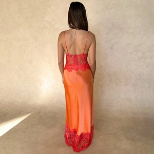 Détail de la robe longue en satin dos nu avec dentelle florale rouge et bretelles fines