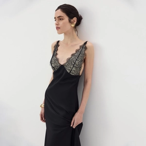 Detail of elegant black satin dress featuring grey floral lace patchwork and slim straps