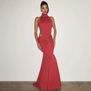 Detail of red halter neck evening gown featuring side waist cutouts and pleated fishtail hem