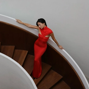 Detailed view of red halter neck dress with high collar on spiral wooden staircase