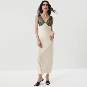 Detail of elegant champagne satin dress with black lace trim and slender straps