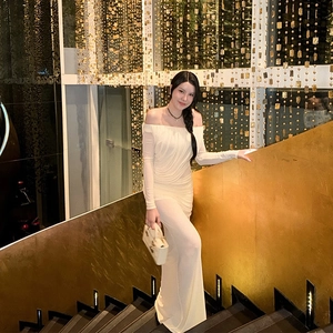 Detail of white off-shoulder maxi dress with pleated fabric and long elegant sleeves