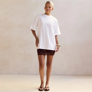 Close-up of white oversized cotton T-shirt paired with a dark brown lace patchwork skirt