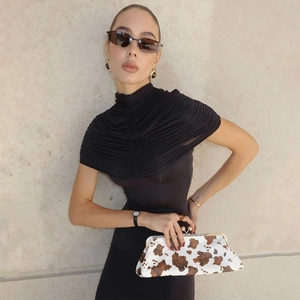 Detail of elegant black turtleneck dress featuring pleated shoulder draping effect