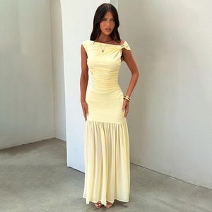 Detail view of yellow asymmetric dress showing gold shoulder ring and waist pleats