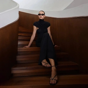 Detail view of elegant black high neck bodice with ruched tailoring on a model