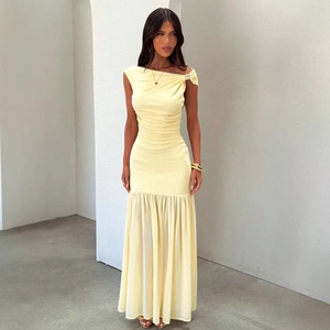 Detail of pale yellow ruched dress featuring an asymmetric shoulder with gold buckle