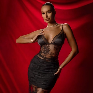 Détail de la robe en satin noir avec décolleté en V et dentelle brodée de roses