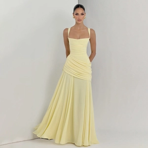 Detail view of yellow pleated evening gown showing thin straps and ruffled waist texture